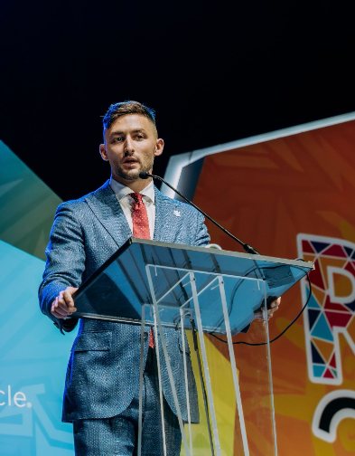Richard speaking on stage at a live event